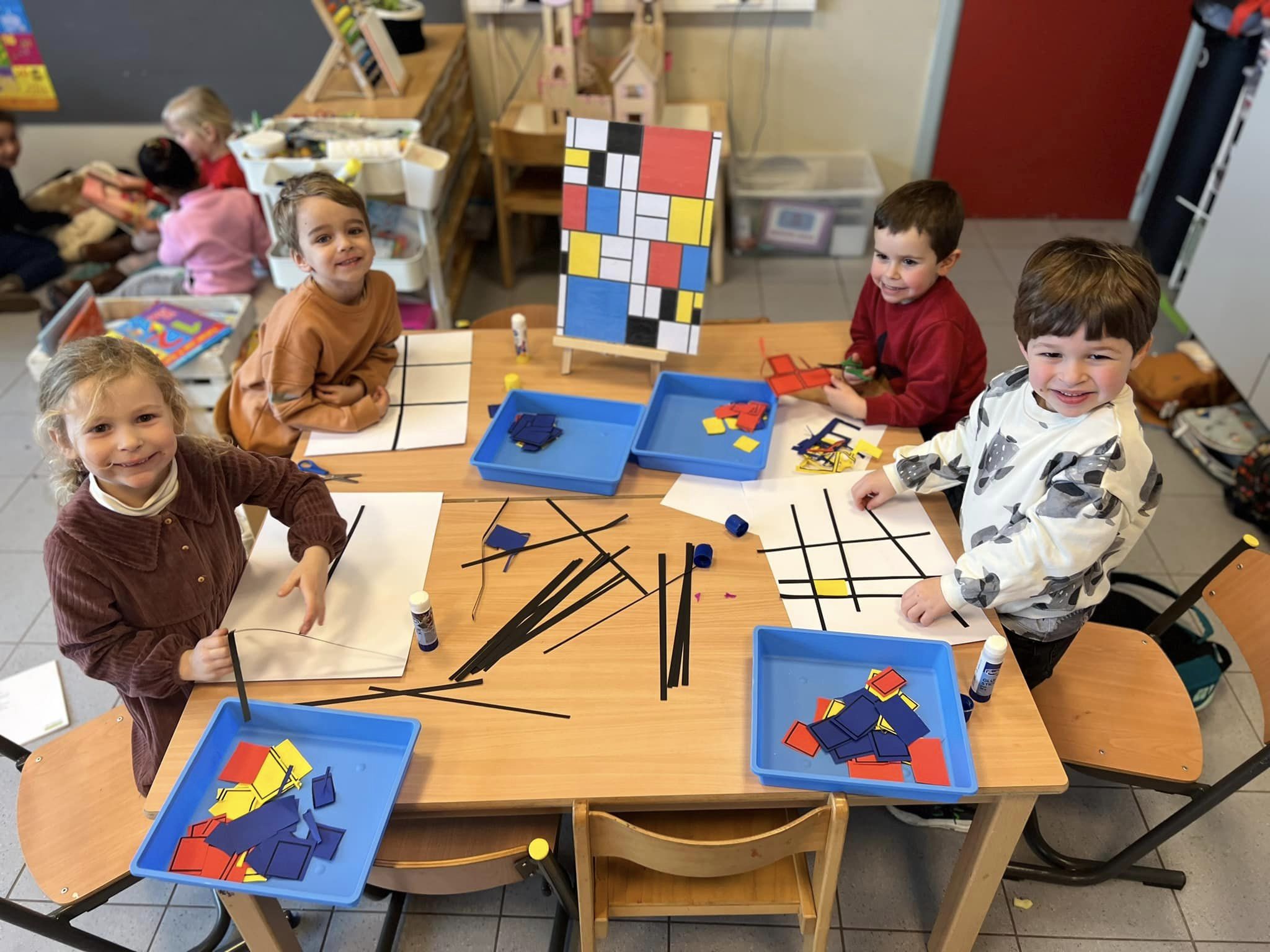 4 kinderen uit de kleuterklas maken een Mondriaan-kunstwerkje